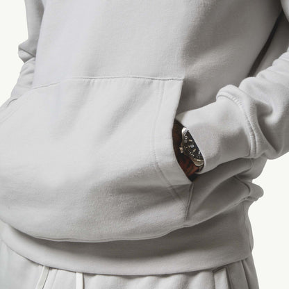 Close up shot of model with hands in his hoodie pocket wearing his Ice Grey Tracksuit, front view