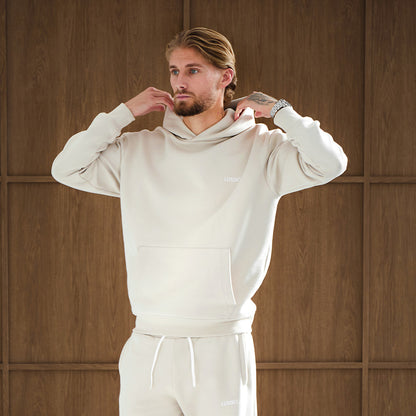 Model Posing looking away to the camera wearing his Stone Tracksuit, adjusting his hood, front view