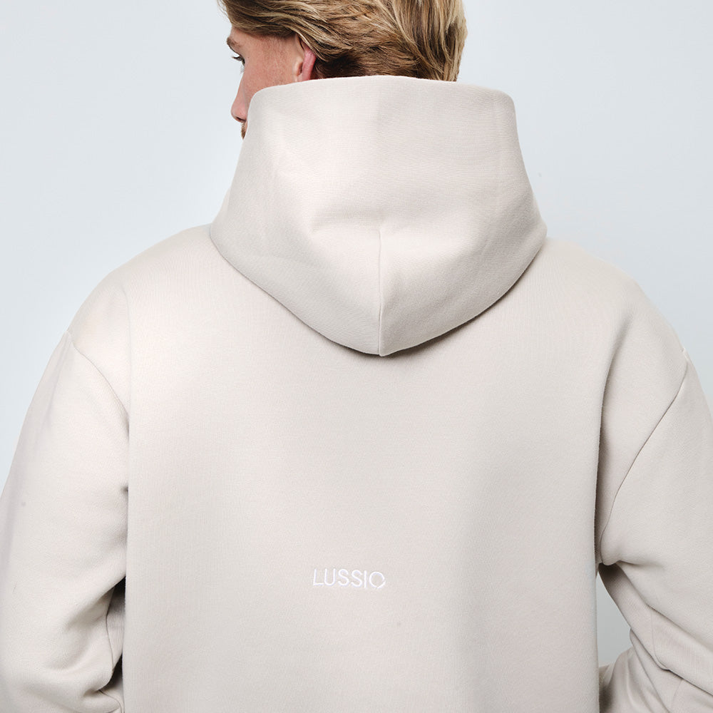 Close up shot of back Lussio logo and hood shape and size, model looking away from the camera, back view