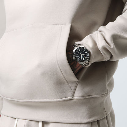 Close up shot of model with hands in his hoodie pocket wearing his Stone Tracksuit, front view