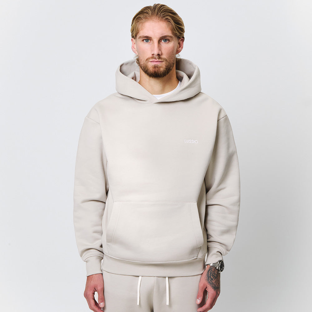 Half body shot of hoodie showing how it looks, model looking at the camera, front view