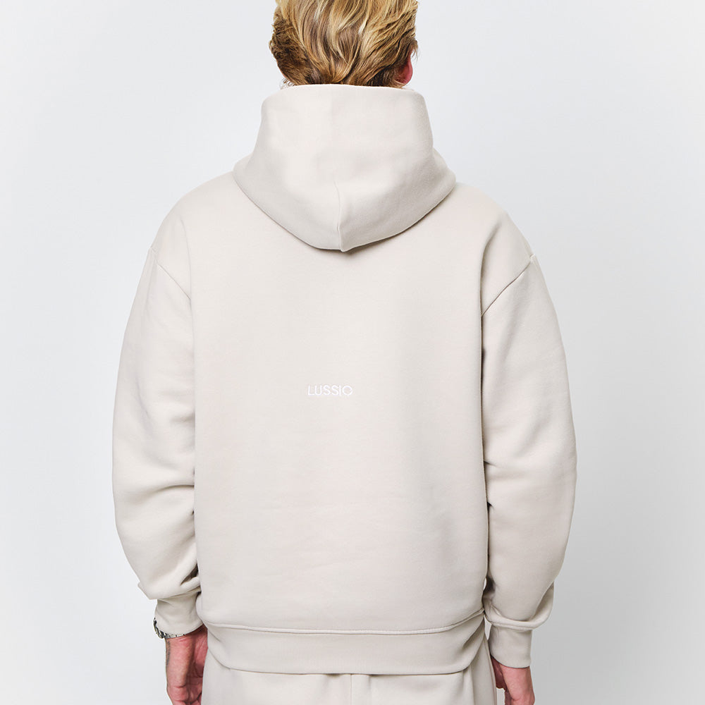 half body shot of back Lussio logo and hood shape and size, model looking away from the camera, back view