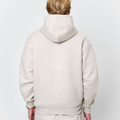 half body shot of back Lussio logo and hood shape and size, model looking away from the camera, back view